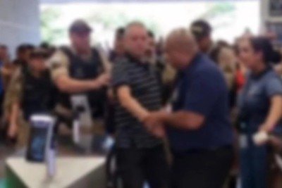 Suspeito foi conduzido por policiais até a viatura após ser detido por suspeita de importunação sexual dentro de clube -  (crédito: Reprodução/Redes Sociais)