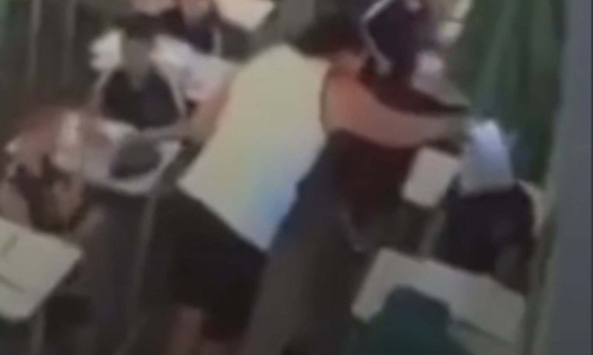 Imagem da câmera de segurança que mostra o momento em que a professora esfrega a prova no rosto do seu aluno n Escola Estadual Celmar Botelho Duarte, no Bairro Providência, na Região Norte de Belo Horizonte - (crédito: Reprodução/Redes Sociais)