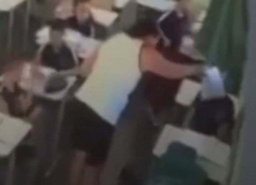 Imagem da c&acirc;mera de seguran&ccedil;a que mostra o momento em que a professora esfrega a prova no rosto do seu aluno n Escola Estadual Celmar Botelho Duarte, no Bairro Provid&ecirc;ncia, na Regi&atilde;o Norte de Belo Horizonte  -  (crédito: Reprodu&ccedil;&atilde;o/Redes Sociais)