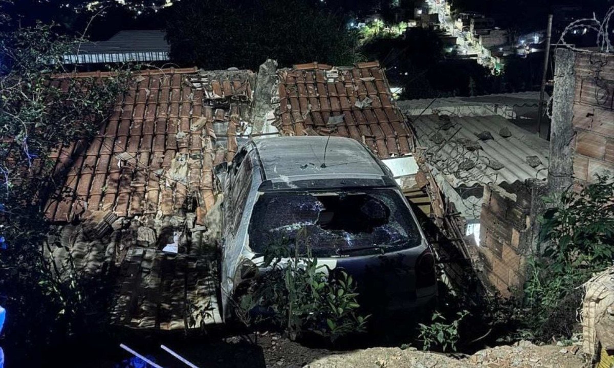 Carro ficou suspenso próximo ao telhado da casa - (crédito: CBMMG/Divulgação)