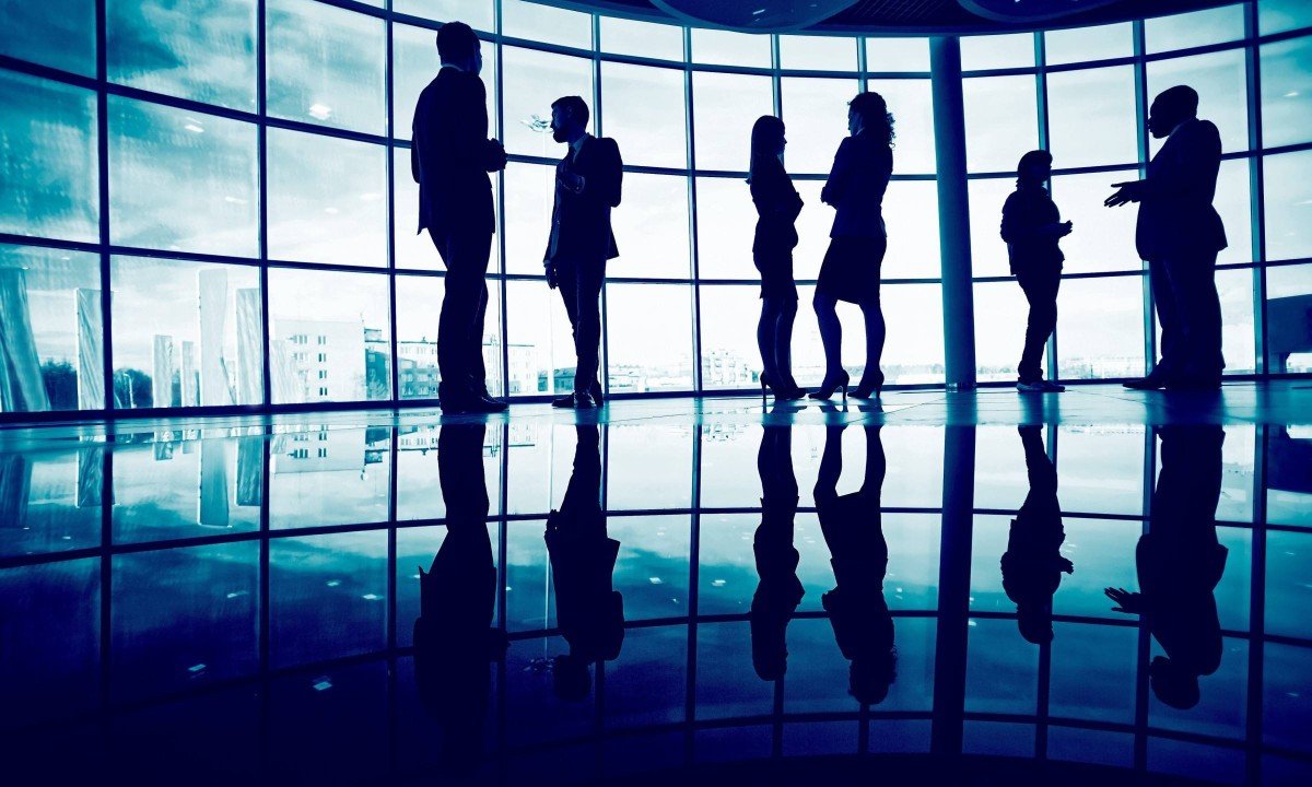 Several white collar workers communicating in office against window
- (crédito: DINO)