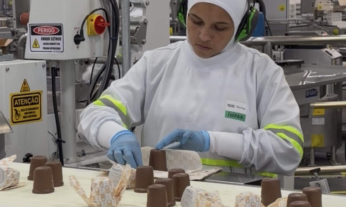 Mãos se dedicam a fazer, no ritmo da esteira, a dobradura do papel que embala a nhá benta - (crédito: Celina Aquino/EM/D.A Press)