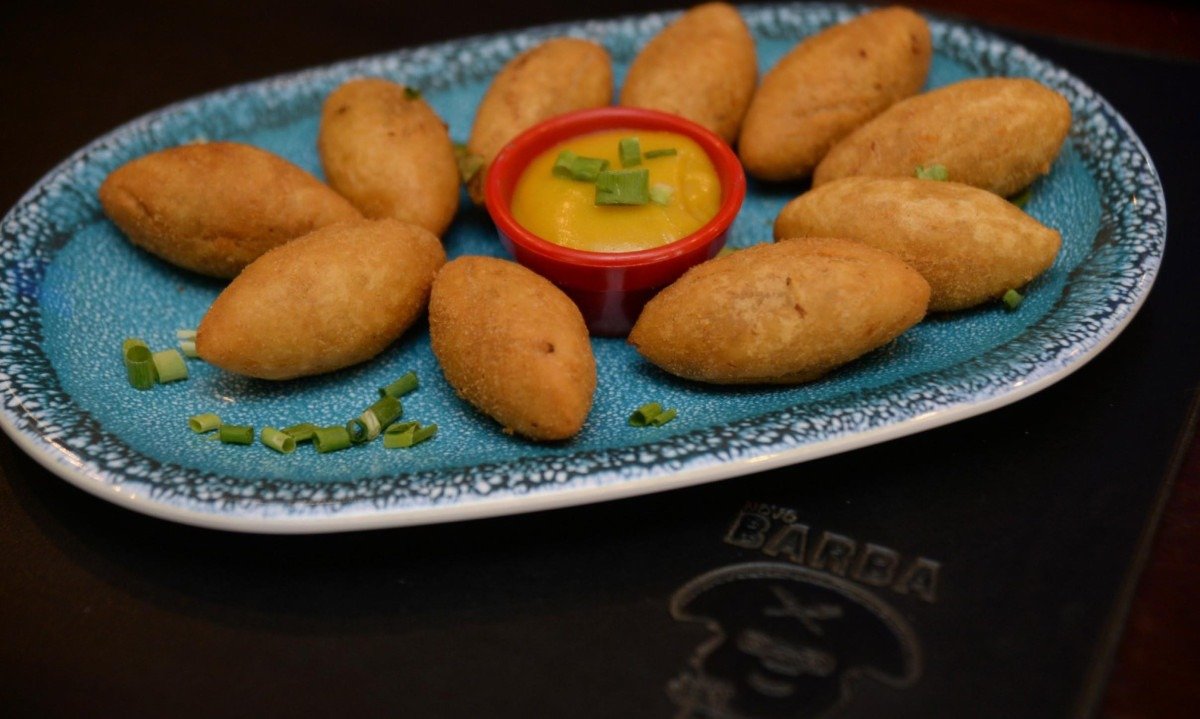 Entre os tira-gostos mais tradicionais de O Barba, est&aacute; o bolinho de mandioca com carne seca e catupiri