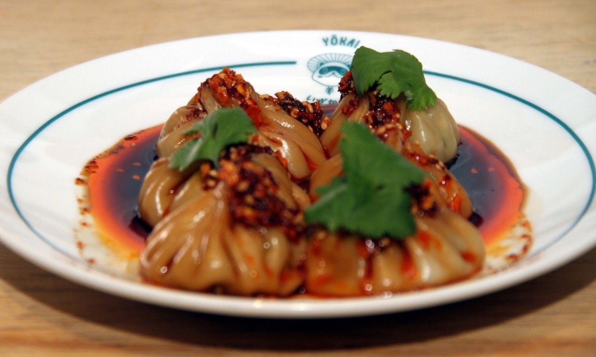 Entre os pratos do Yokai com chili crunch, est&aacute; o dumpling cozido e recheado com sobrecoxa e caldo de frango
