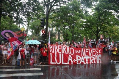 Em Belo Horizonte, a espera é acompanhada por chuva. Mesmo assim, militantes permaneceram na Praça da Liberdade com bandeiras, faixas e bonés vermelhos -  (crédito: Marcos Vieira/EM/DA.Press)
