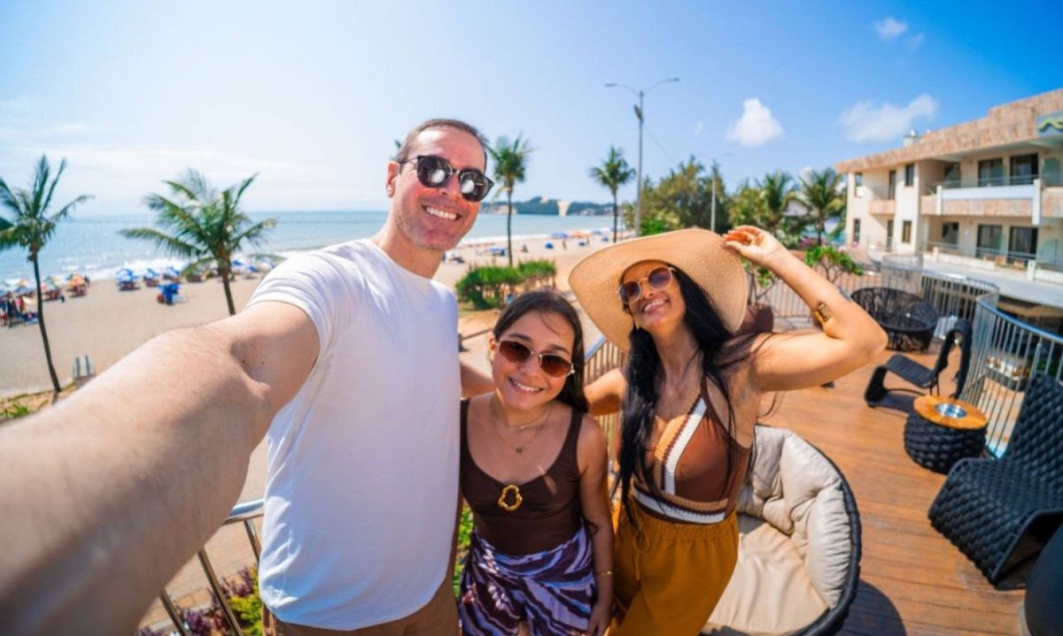 Hóspedes sorridentes fazem selfie no Deck, com a praia e o hotel Esmeralda ao fundo - (crédito: Esmeralda Praia Hotel)