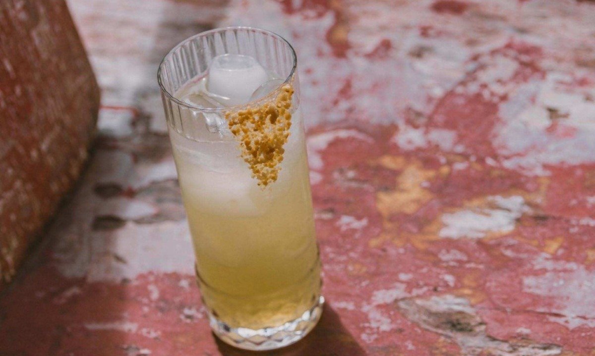 O drinque de cacha&ccedil;a, caju, tomilho, lim&atilde;o e amendoim triturado no copo &eacute; para ser como um beijo salgado na beira-mar 