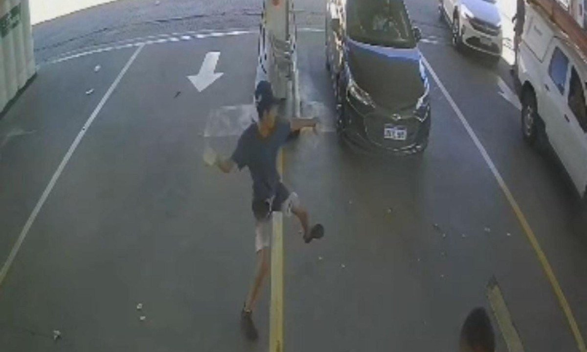 Imagens das câmeras de segurança de um posto de combustível próximo ao Shopping Del Rey mostram um dos homens arremessando pedras contra um frentista - (crédito: Reprodução)