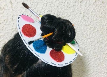 Acess&oacute;rios criativos como este penteado inspirado em paleta de pintor exemplificam a imagina&ccedil;&atilde;o no Dia do Cabelo Maluco. -  (crédito: @reinaelzabeth / Redes Sociais)