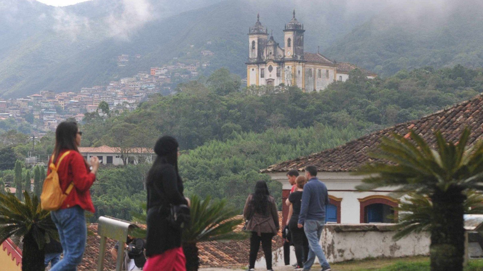 Turistas visitam Ouro Preto, tendo ao fundo as igrejas barrocas da cidade hist&oacute;rica mineira