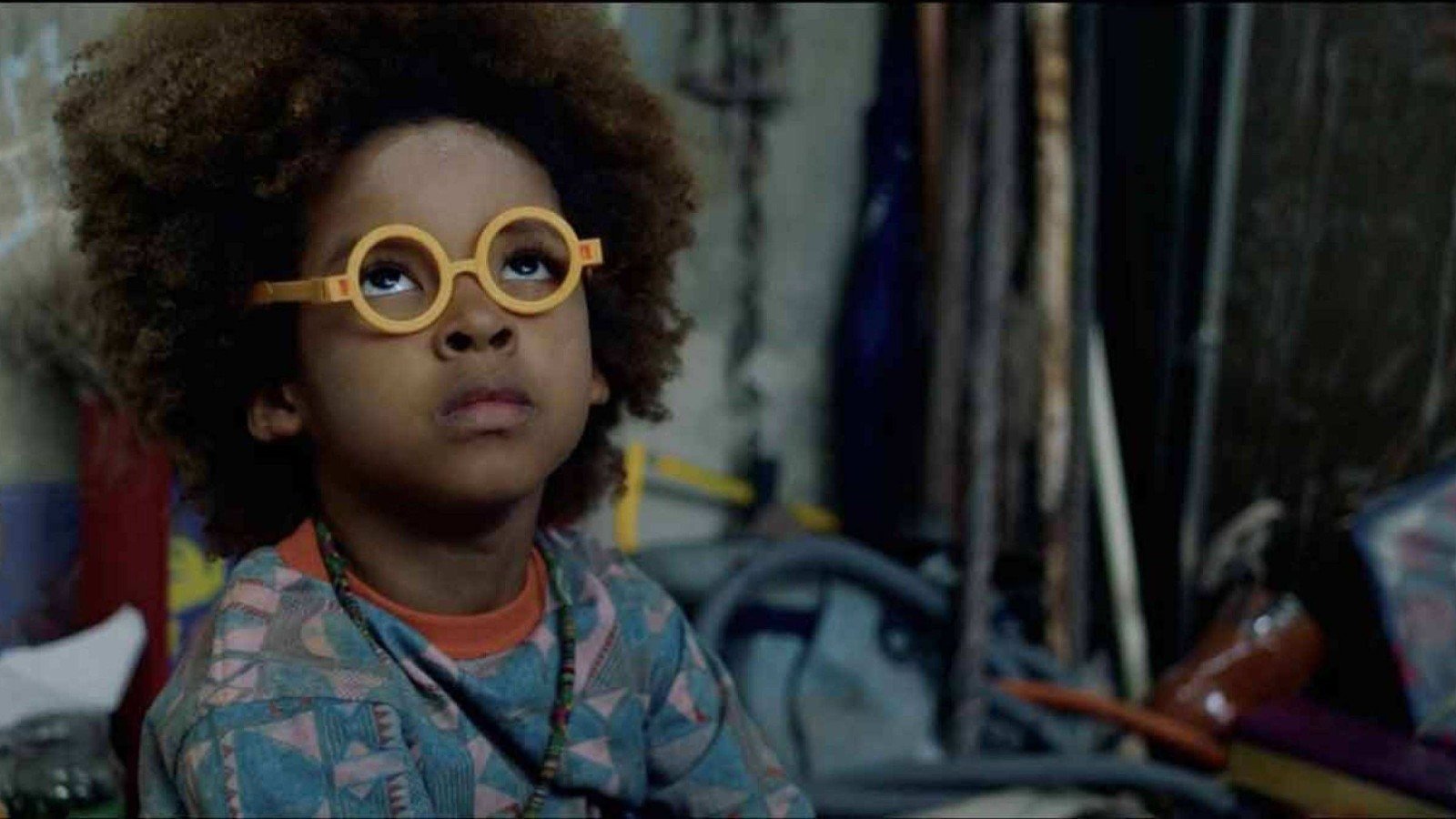Ator mirim Efraim Santos usa &oacute;culos redondo de aro amarelo em cena do filme Nosso segredo