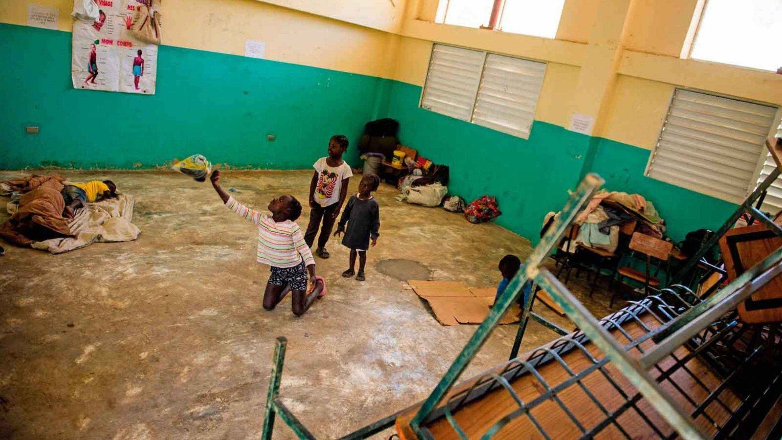 No Haiti, a inf&acirc;ncia tamb&eacute;m foi obrigada a fugir. Em Porto Pr&iacute;ncipe, crian&ccedil;as crescem entre barracas improvisadas e escolas transformadas em abrigos, enquanto a viol&ecirc;ncia das gangues expulsa fam&iacute;lias de suas casas. Onde antes havia salas de aula, agora h&aacute; colch&otilde;es, medo e incerteza. Algumas crian&ccedil;as sequer conheceram a paz; outras s&atilde;o recrutadas por grupos armados antes de aprender o significado da liberdade. Em um pa&iacute;s onde at&eacute; brincar se tornou um risco, sobreviver ocupa o lugar dos sonhos.
