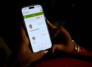 Eleitor acompanha pelo celular a apuração dos votos para presidente do Brasil
 -  (crédito: Luis Robayo/AFP)