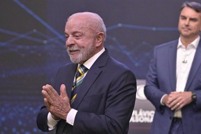 Fl&aacute;vio Bolsonaro (ao fundo) em estrat&eacute;gia para gerar imagens de confronto atr&aacute;s de Lula durante debate presidencial na Band -  (crédito: Renato Pizzutto/Band)