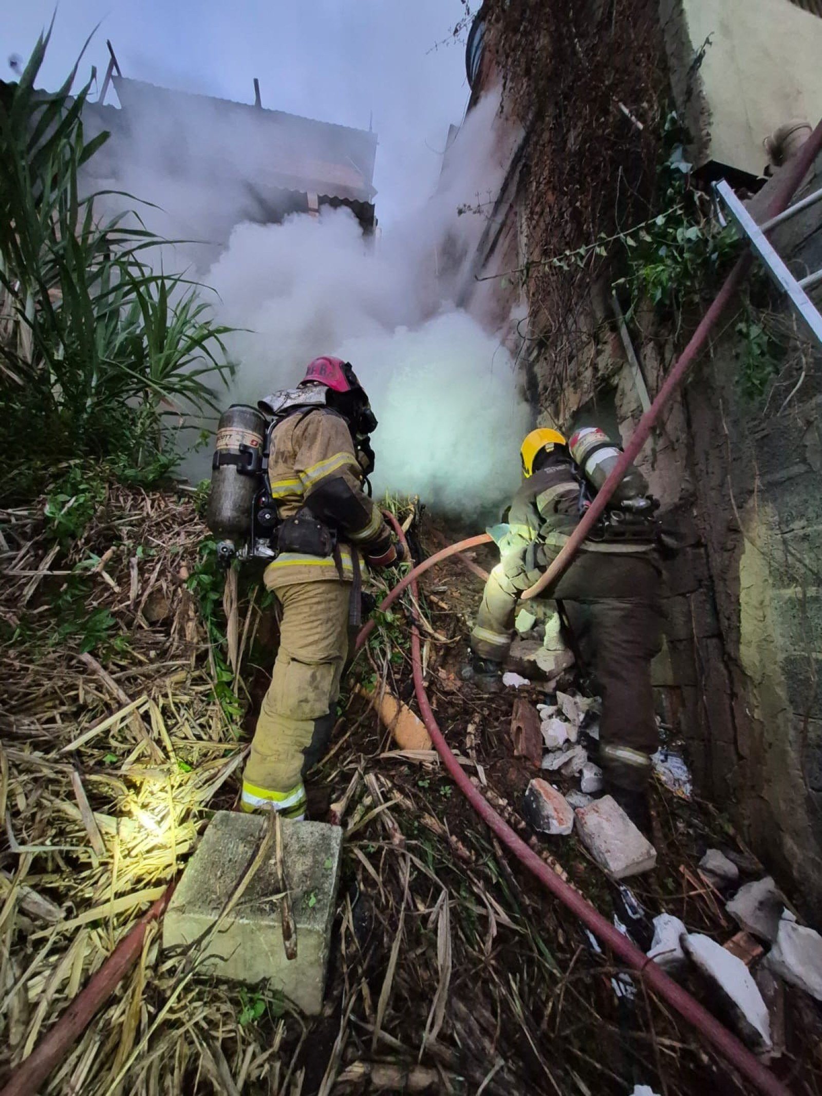 Bombeiros precisaram abrir buraco em um dos muros da casa para ventilar o local e combater as chamas-CBMMG/Divulgação