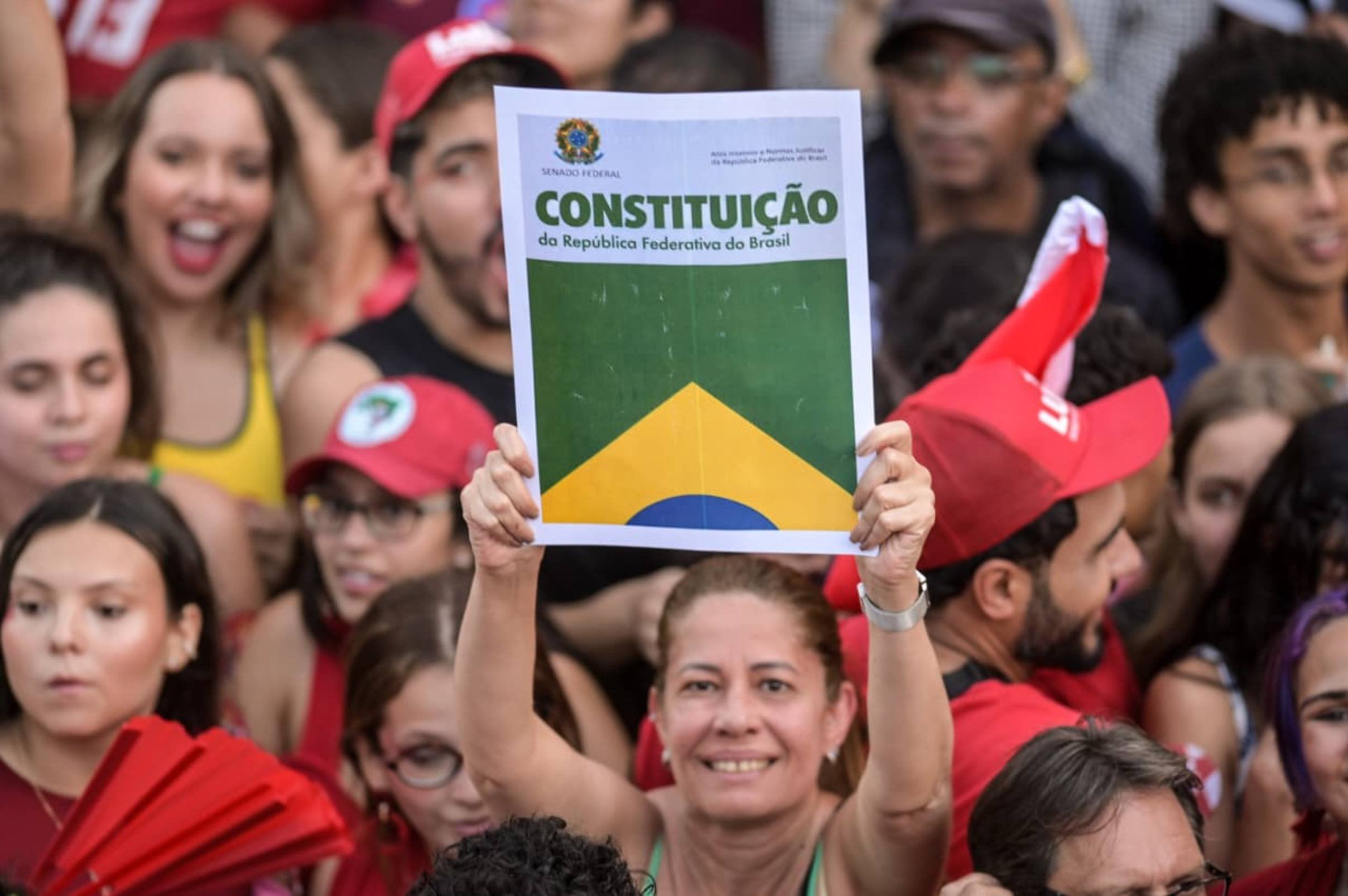 Eleitora ergue cartaz da constitui&ccedil;&atilde;o em ato desta quarta (21) 