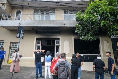 Pessoas acompanham o trabalho do CBMMG a contenção do incêndio no restaurante Sabor do Dia -  (crédito: Leandro Couri/EM )