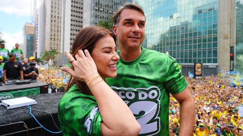 Fl&aacute;vio Bolsonaro e sua esposa, Fernanda, em evento p&uacute;blico, antes de sua controversa sa&iacute;da do Brasil rumo aos EUA -  (crédito: Charles Vieira/DIVULGA&Ccedil;&Atilde;O)
