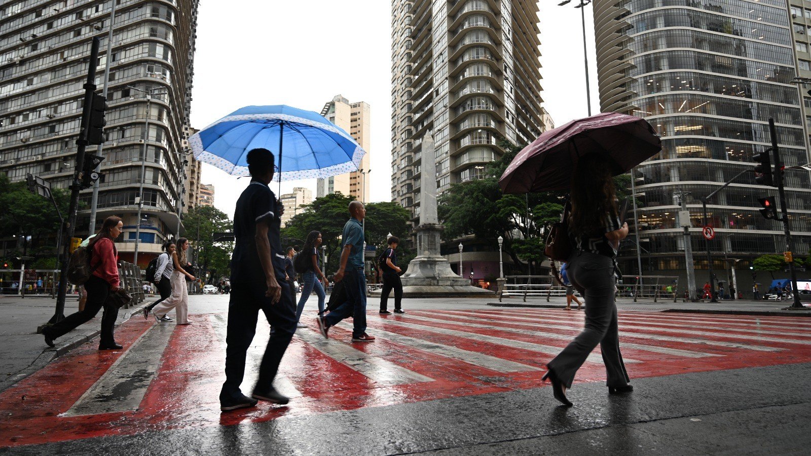 Pedestres enfrentam a instabilidade do tempo e as pancadas de chuva que atingem Belo Horizonte nesta sexta-feira -  (crédito: Leandro Couri/EM/D.A.)