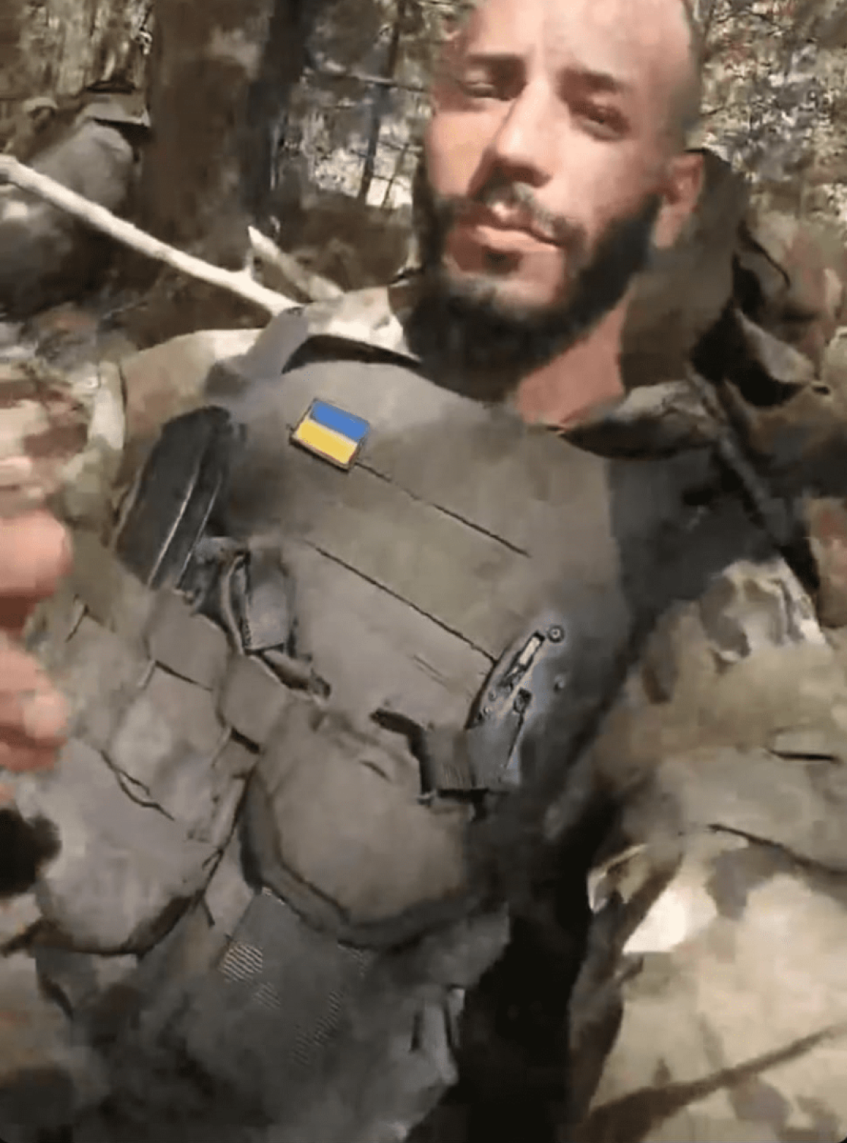 homem cabelo raspado e farda do exército com a bandeira da ucrânia 