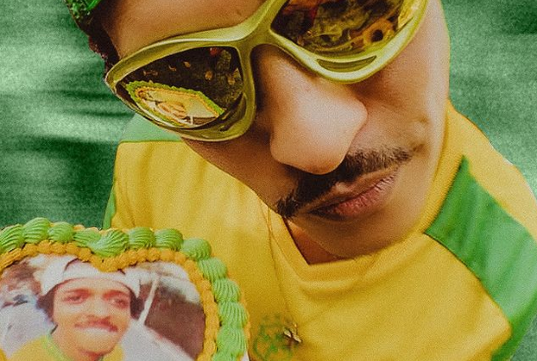 Bruno Mars se veste verde-amarelo e olha para a câmera