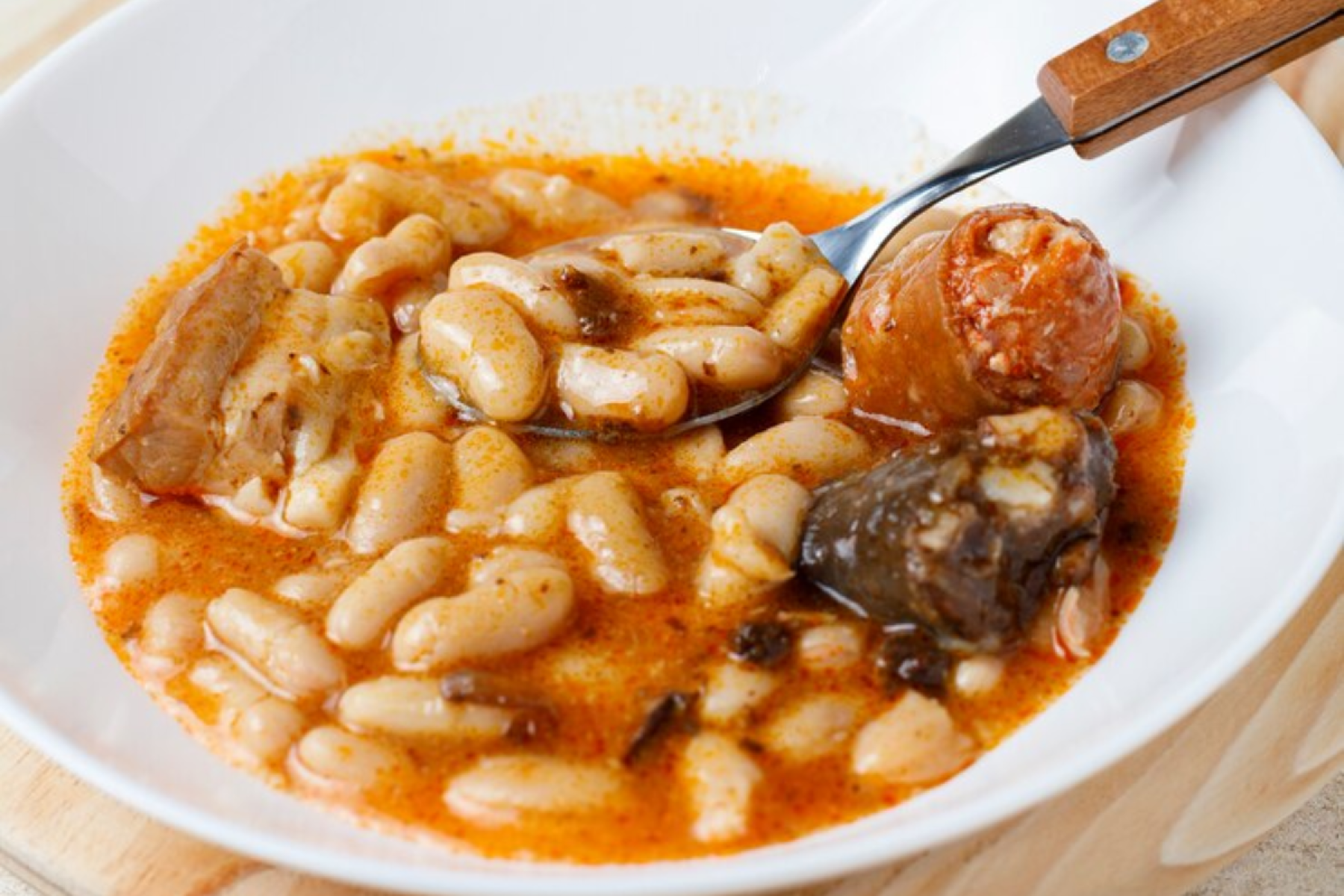 Fabada Asturiana: ensopado robusto típico das Astúrias, preparado com feijão branco, chorizo, morcela, toucinho e carne de porco. Cozido lentamente, é servido como prato principal em dias frios.