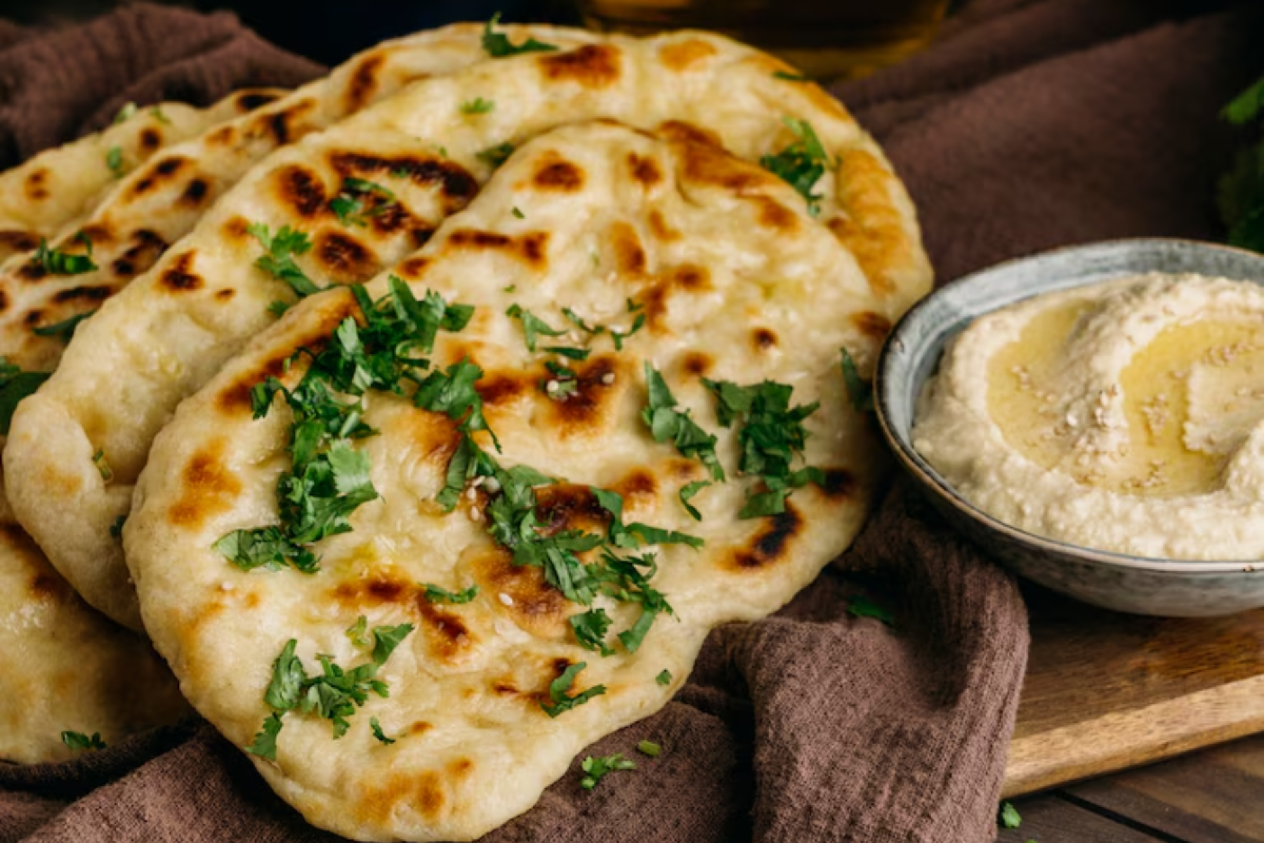 1º Butter Garlic Naan da  Índia (Nota: 4.7) - Tradicional pão indiano assado no tandoor, feito com farinha maida, dahi, ghee e finalizado com alho e manteiga. Macio, aromático e extremamente saboroso.
-Freepik
