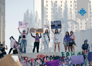 Grupo de mulheres participa de um protesto feminista em espaço urbano, segurando cartazes com mensagens contra a violência de gênero. cena transmite união, força e reivindicação por direitos e segurança para as mulheres. -  (crédito: Reprodução Educando Seu Bolso)
