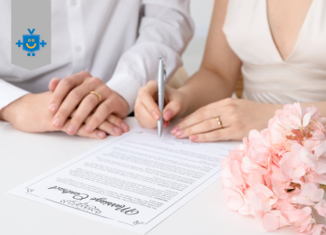 Casal sentado lado a lado enquanto assina um documento de formalização da união estável, com flores rosas apoiadas sobre a mesa. -  (crédito: Reprodução Educando Seu Bolso )