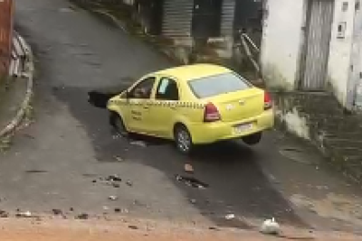 O veículo que aparenta ser um táxi ficou parcialmente dentro da cratera -  (crédito: Redes Sociais/Reprodução)