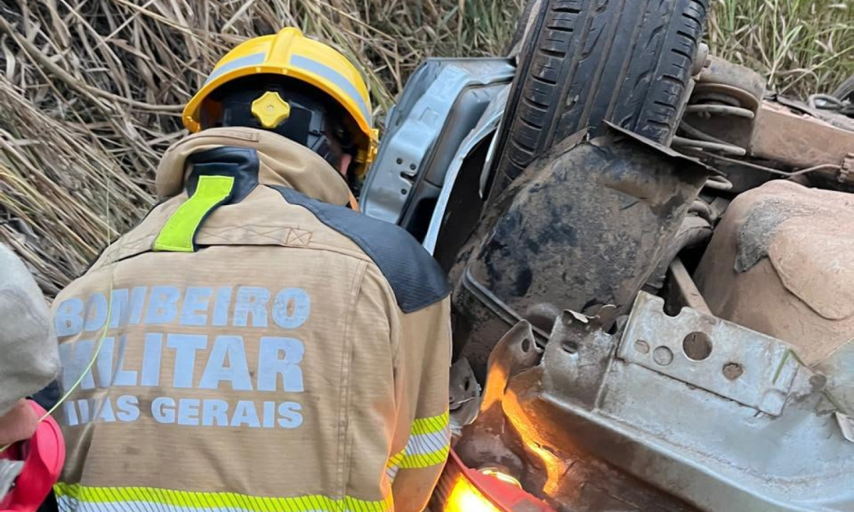 Equipe do Corpo de Bombeiros faz a retirada do corpo do jovem da estrutura do carro - (crédito: CBMMG/Divulgação )