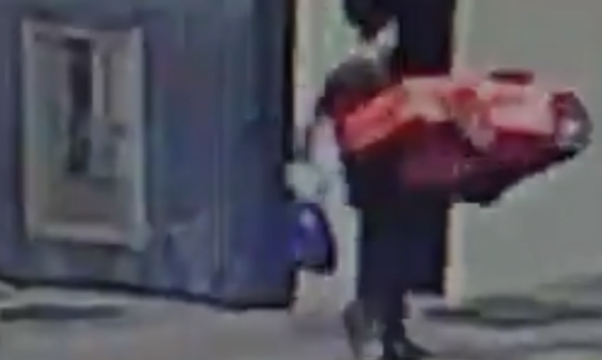 Momento em que o homem é flagrado por câmera de segurança caminhando com o carrinho de brinquedo furtado - (crédito: Reprodução redes sociais)