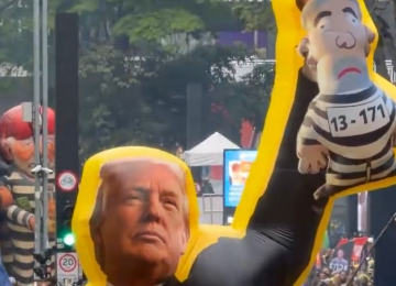 Boneco infl&aacute;vel retratando Donald Trump segurando figura de Lula em uniforme de presidi&aacute;rio com '13-171' no ato da Paulista -  (crédito: Reprodu&ccedil;&atilde;o/Redes sociais)