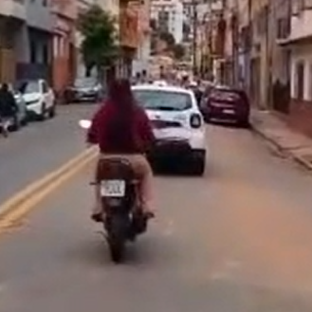 Mulher pilota sem capacete atrás de viatura da PM; veja o vídeo