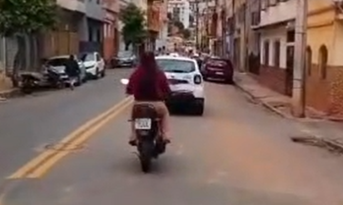 Mulher é flagrada sem capacete logo atrás de viatura da PM em Caratinga, no Vale do Rio Doce - (crédito: Redes Sociais/Reprodução)