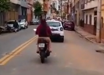 Mulher é flagrada sem capacete logo atrás de viatura da PM em Caratinga, no Vale do Rio Doce -  (crédito: Redes Sociais/Reprodução)