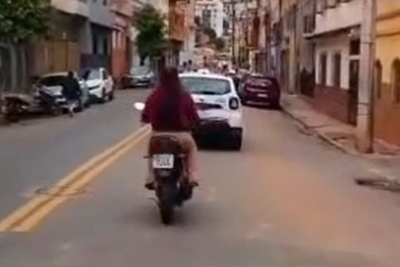 Mulher é flagrada sem capacete logo atrás de viatura da PM em Caratinga, no Vale do Rio Doce -  (crédito: Redes Sociais/Reprodução)