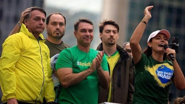 Jair Bolsonaro ao lado do filho Fl&aacute;vio e da esposa Michelle, figuras centrais da fam&iacute;lia Bolsonaro e com atua&ccedil;&atilde;o destacada na pol&iacute;tica nacional -  (crédito: AFP via Getty Images)