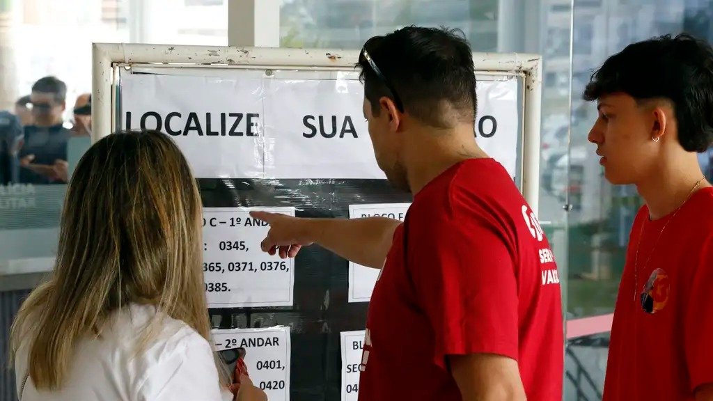 Eleitores consultam lista de locais de vota&ccedil;&atilde;o, pr&aacute;tica comum ap&oacute;s altera&ccedil;&otilde;es feitas pela Justi&ccedil;a Eleitoral para o pleito -  (crédito: Bruno Peres/Ag&ecirc;ncia Brasil)