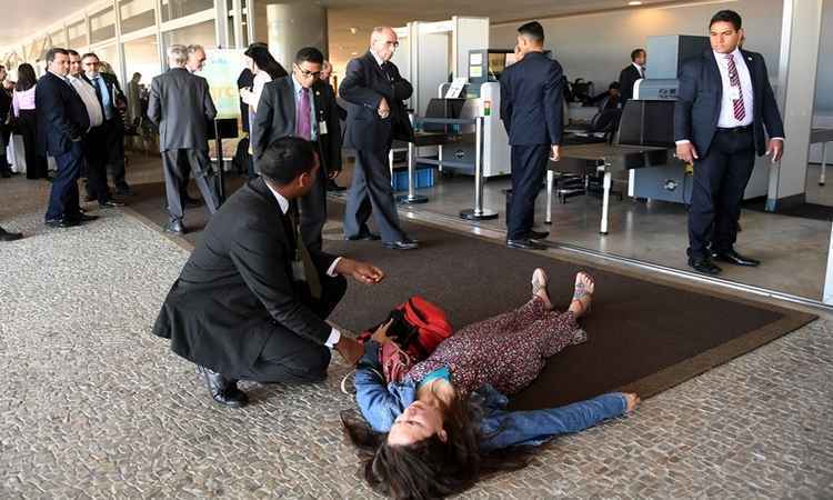 Mulher deita no chão do Palácio do Planalto e grita que ama Temer - Evaristo Sá/AFP 