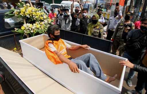 Decreto obriga quem não usar máscara a deitar em caixão no meio da rua - Fahmi Dolli / AFP