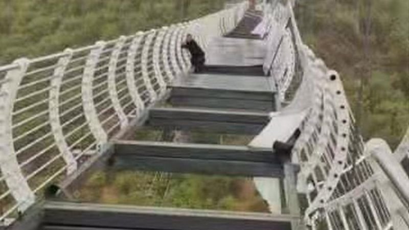 Ponte de vidro quebra e turista fica pendurado a 100 metros de altura - XINHUA/WEIBO