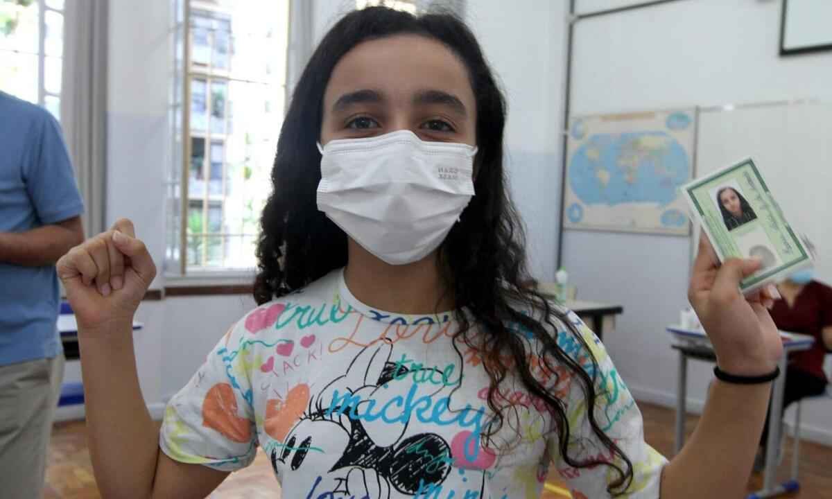 Menina de 10 anos comemora a primeira dose da vacina contra COVID, em BH - Jair Amaral/EM/D.A Press