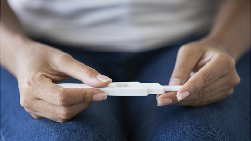 Duas mãos seguram um aparelho que parece ser um teste de gravidez -  (crédito: Getty Images)