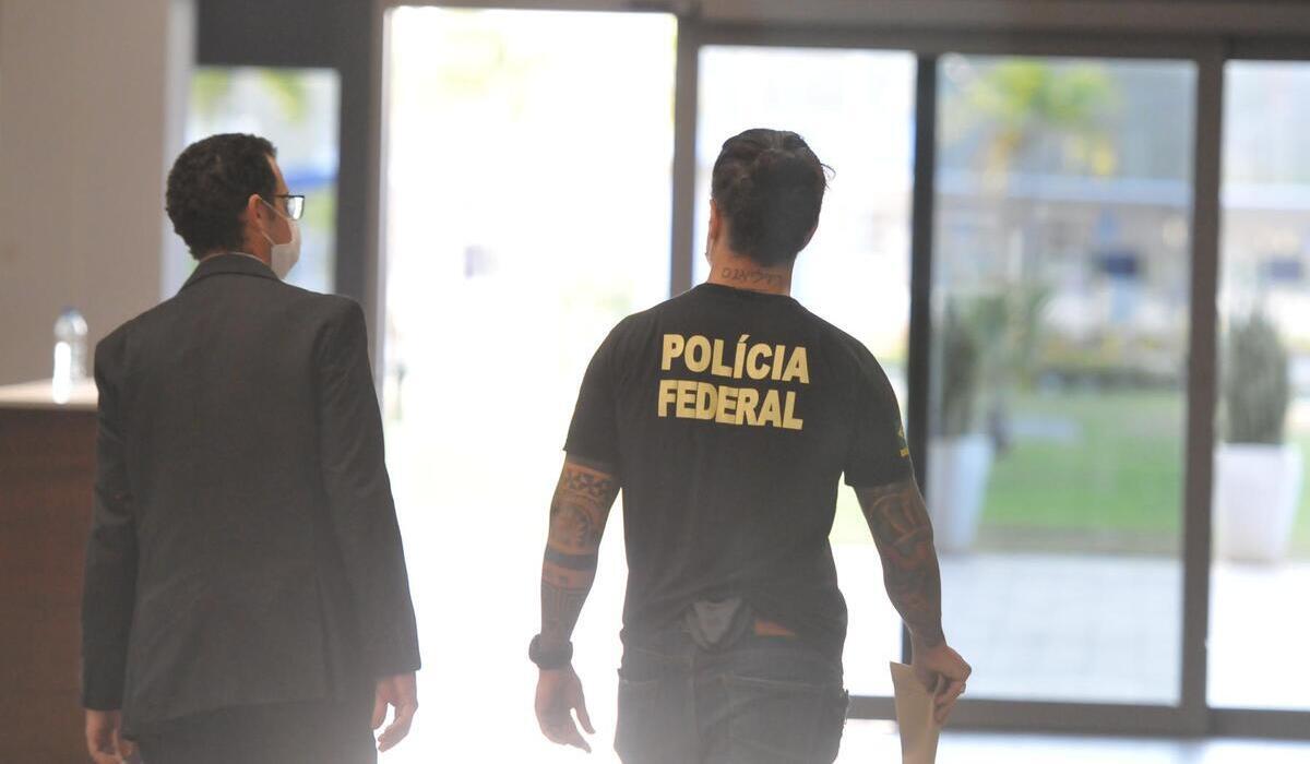 Policial federal ao lado de outro homem, no aeroporto de Confins. -  (crédito: Alexandre Guzanshe/EM/D.A Press)