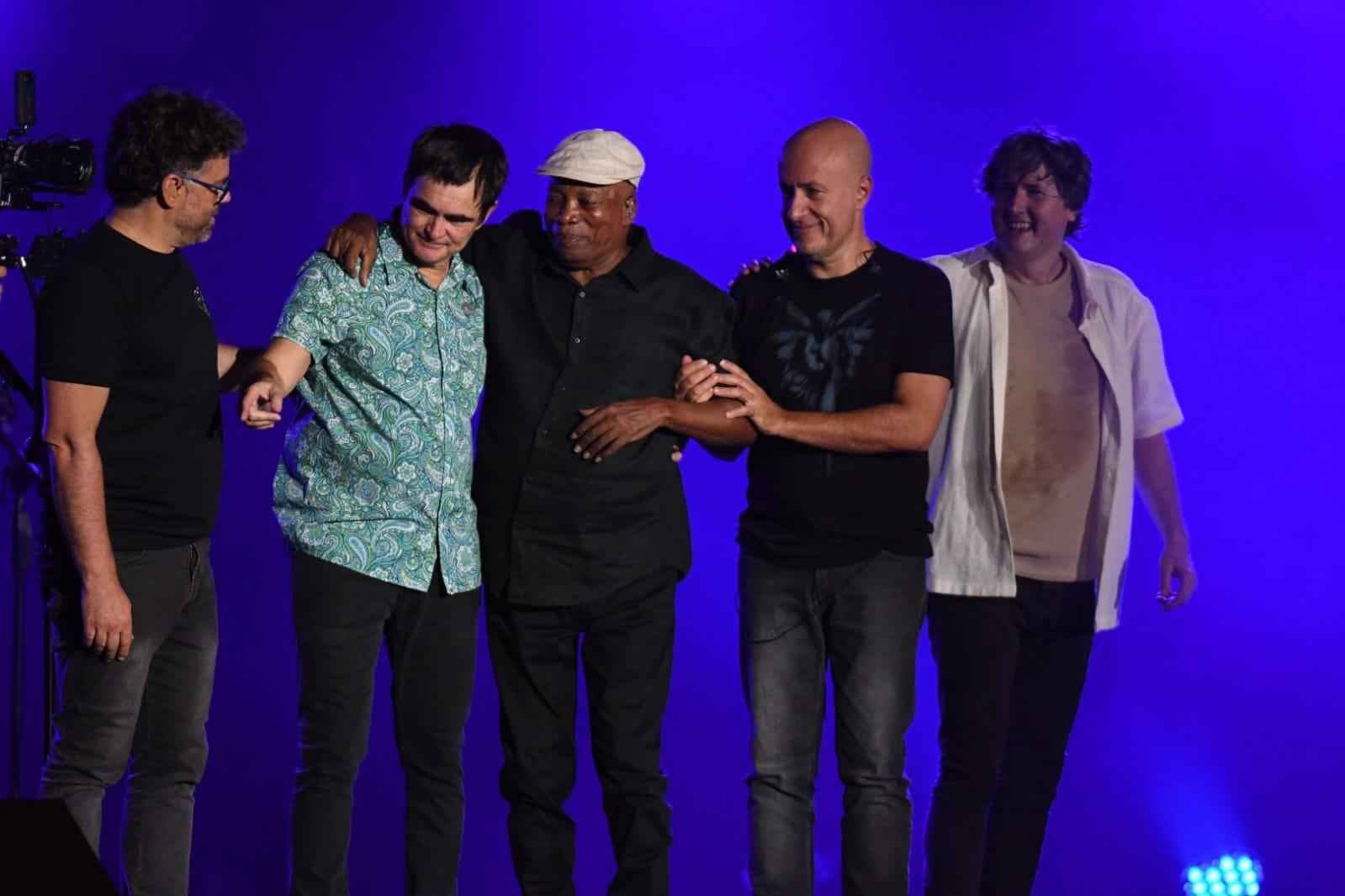 Milton Nascimento e os quatro integrantes do Skank, de p&eacute;, no palco