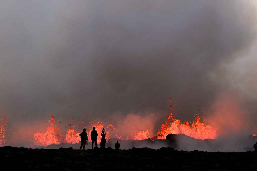 Curiosos visitam vulcão para ver lava 'tão laranja como o Sol' - Kristinn Magnusson / AFP