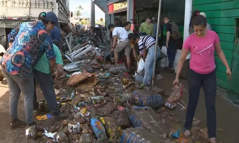 RS: moradores retiram alimentos da lama após destruição de supermercado - Reprodução/TV Globo
