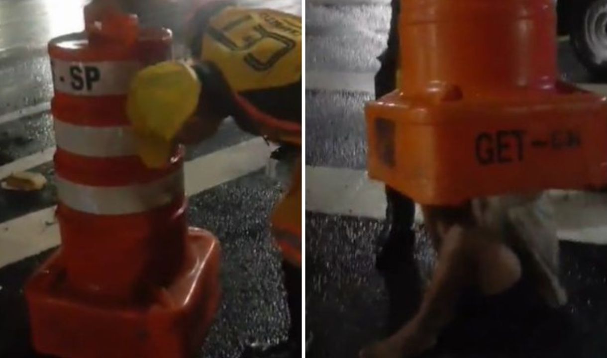 Vídeo: Homem se esconde da chuva dentro de cone de trânsito e fica entalado - Reprodução / X